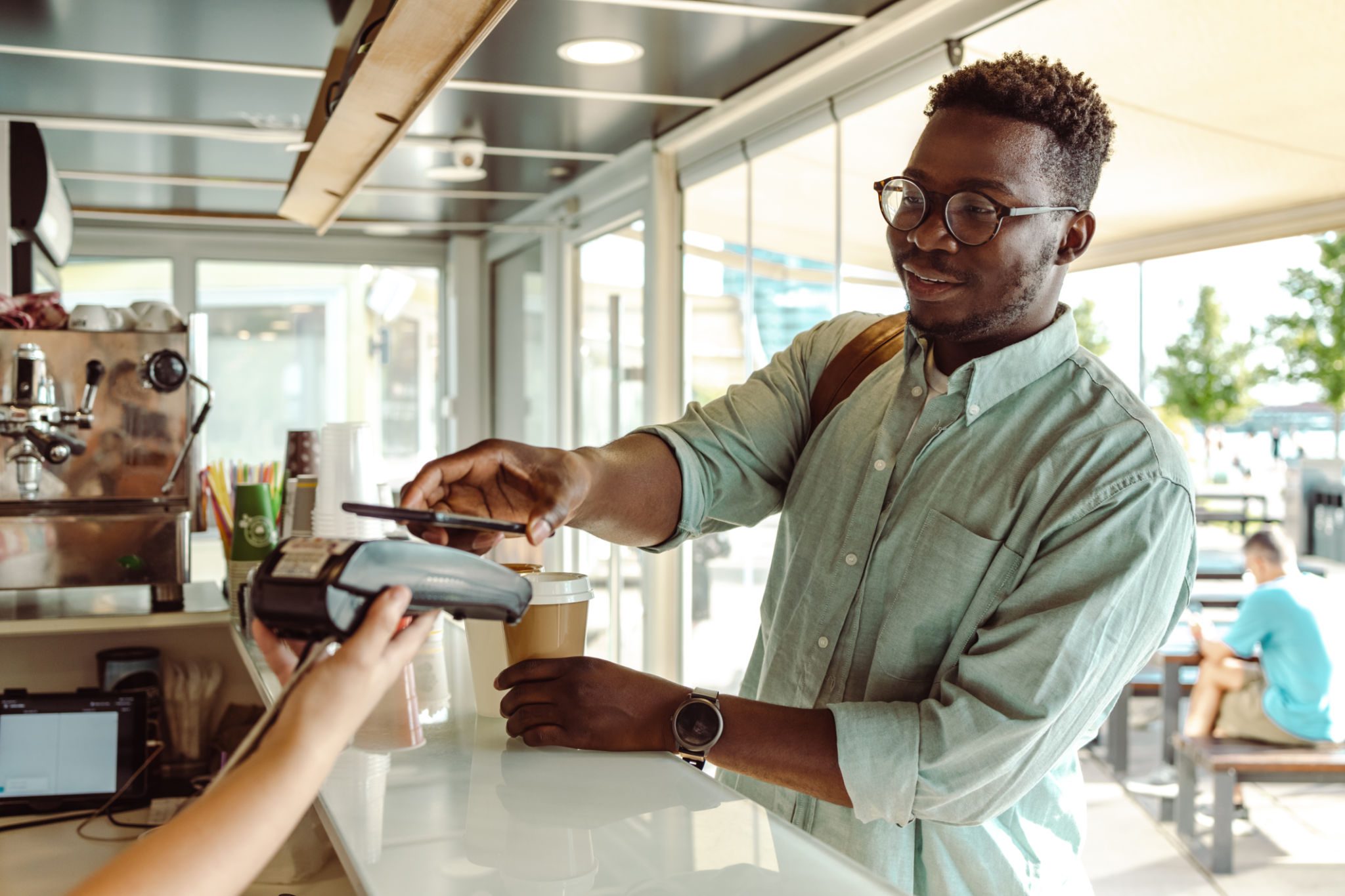 Man making contactless payment at cafe counter